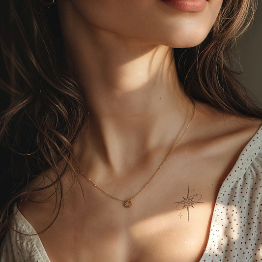 A close-up of a woman's neck wearing a necklace and a star tattoo on her collarbone. - Wide Awake NYC